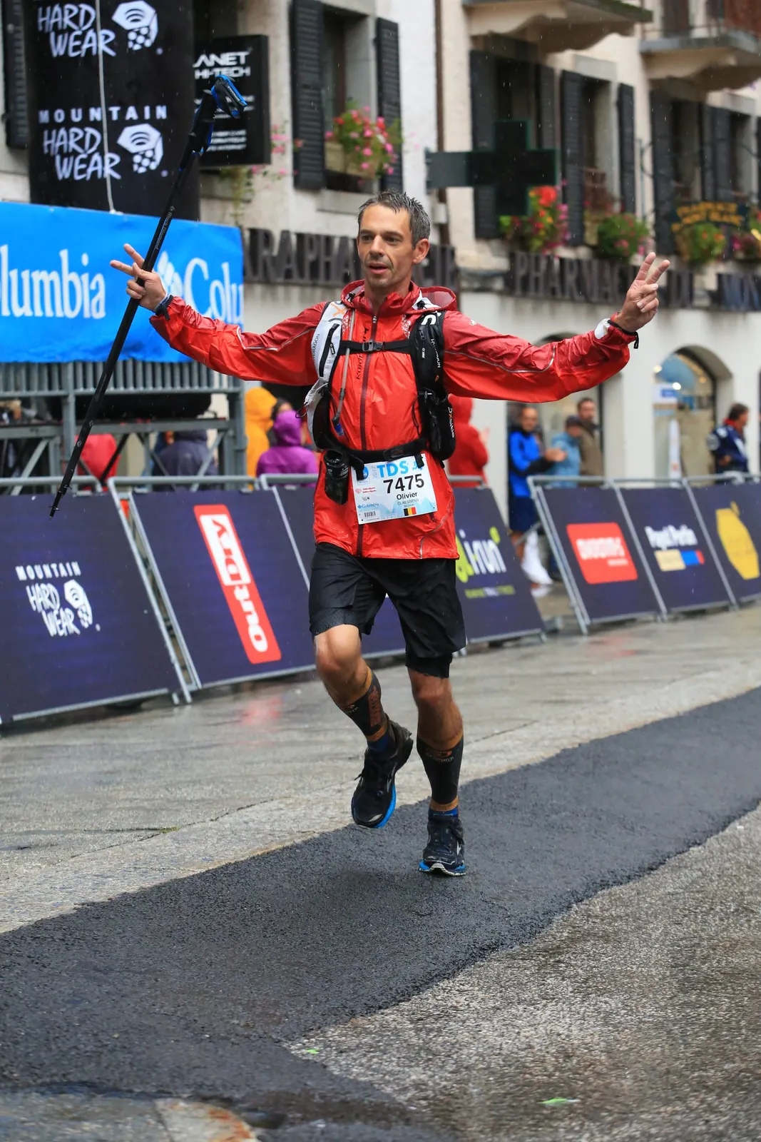 Coureur en rouge levant les bras après sa course.